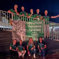 Kan een afbeelding zijn van 9 mensen, golfende mensen en de tekst 'International Tournament Tug of War T.T.V. EIBERGEN SIdS 10 1 May'